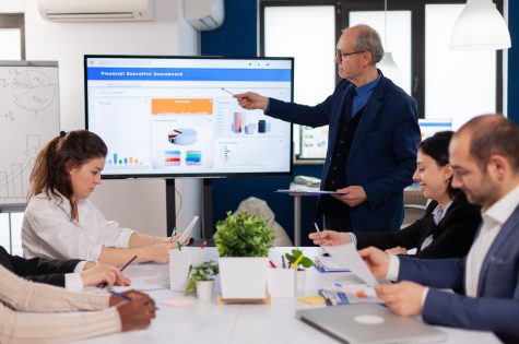 senior-team-leader-explaining-presentation-discussion-conference-room-briefing-planning (1)